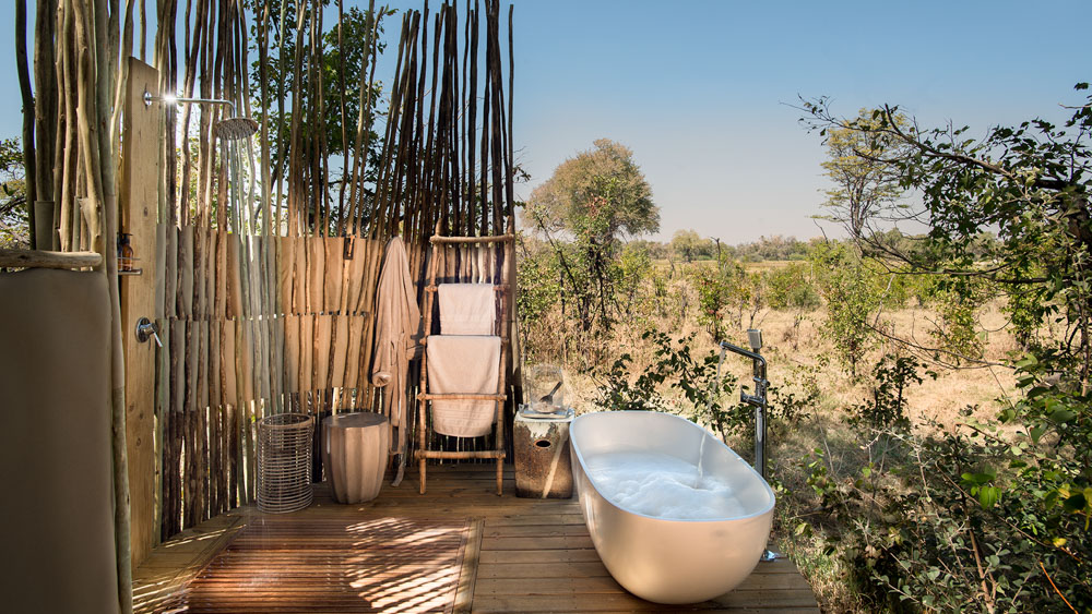 Luxury outdoor bathtub in the African wilderness , down to earth safari comfort surrounded by nature.
