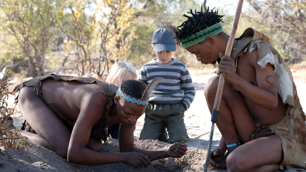 Little explorer watching the San tribe making a fire.