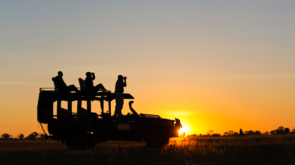silhouette of safari vehicle with guests on a gamedrive at sunset – how we design and plan your safari
