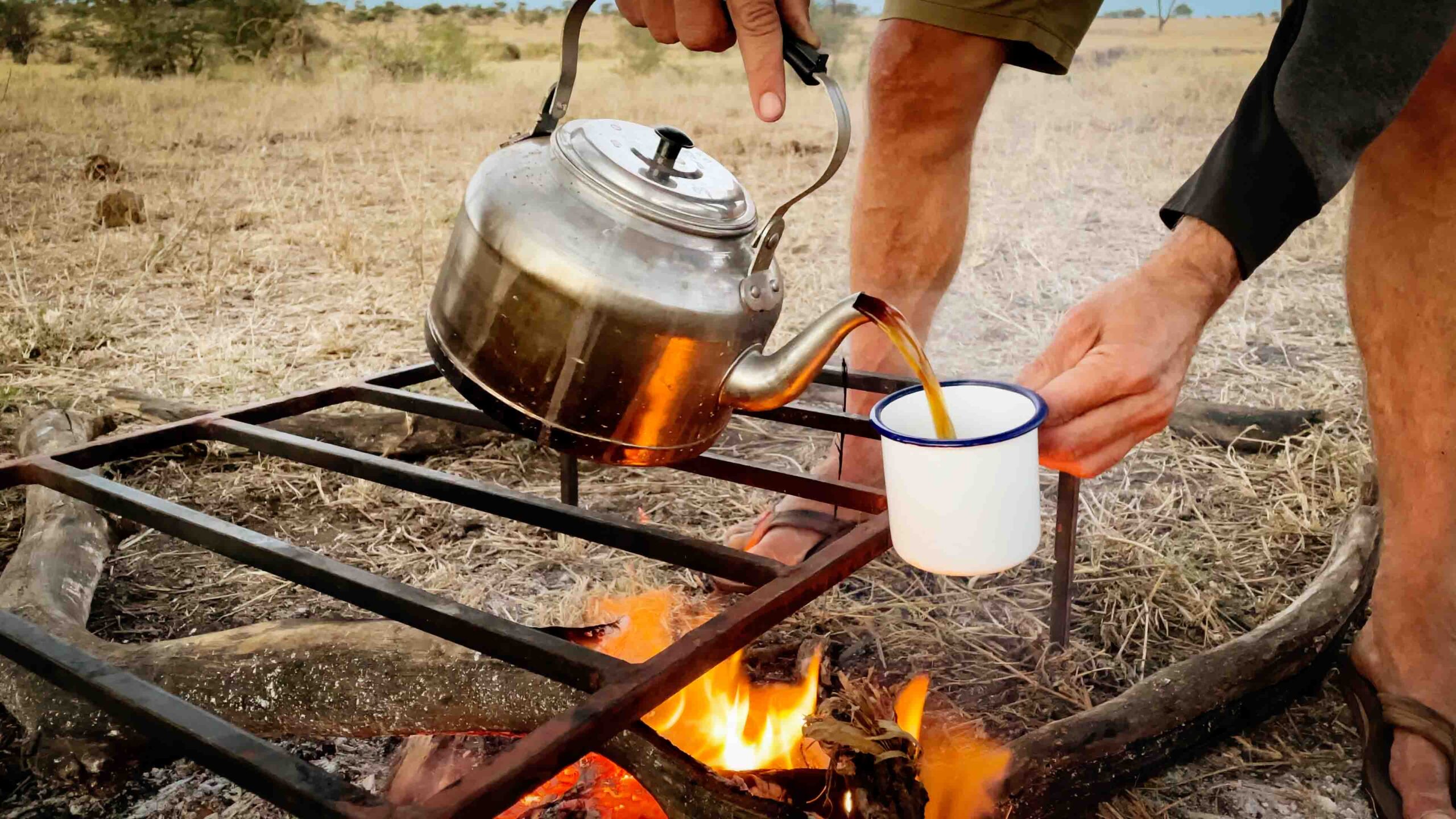 down to earth luxury safari campfire with kettle pouring tea in the African bush